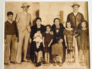 Sylvia's grandfather is on the left next to his wife and mother, along with their children. Sylvia’s father is the tallest.