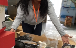 Rosa Aragon showing boxes filled with food